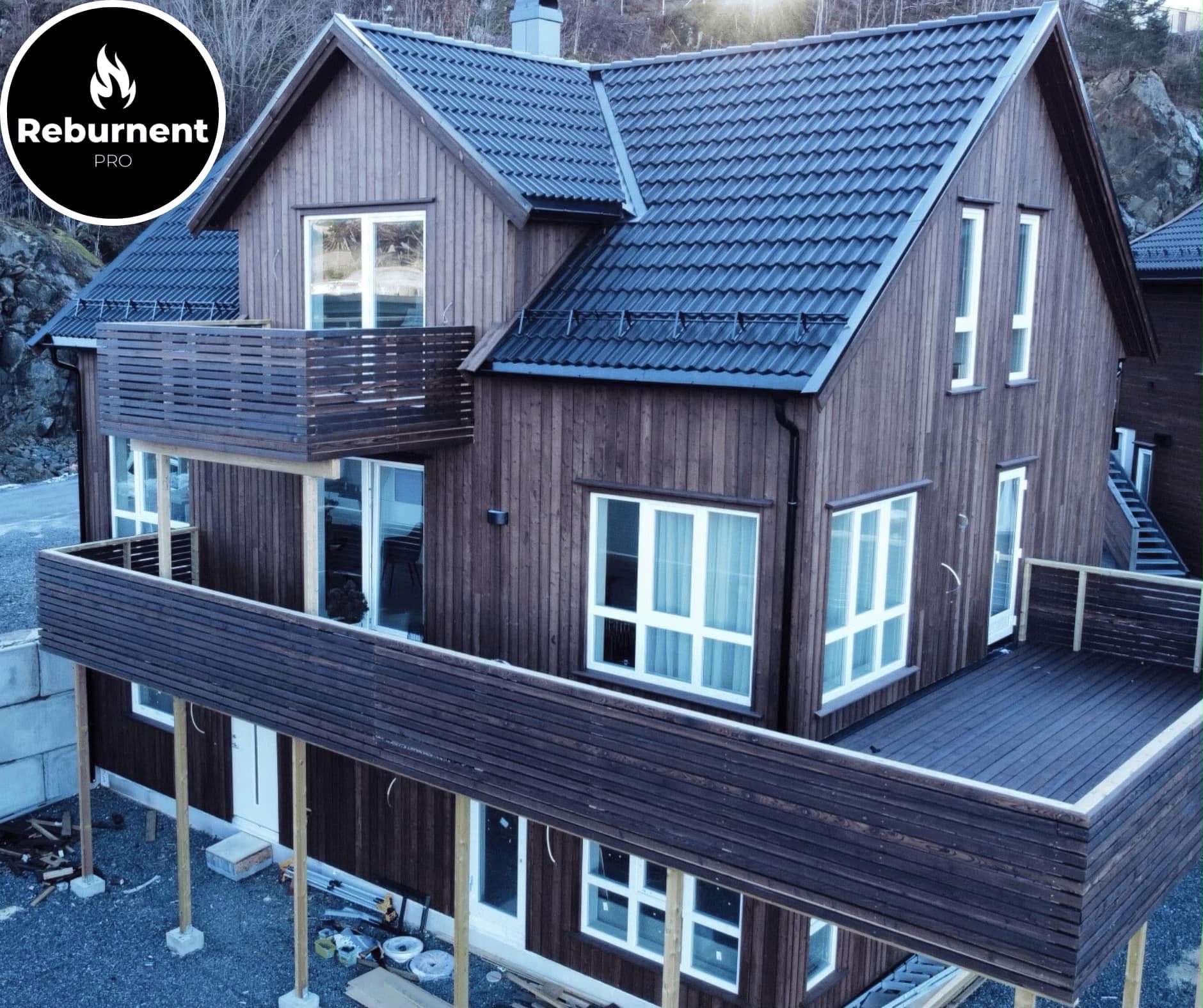 Charred timber house with balconies, clad in Reburnent Pro boards