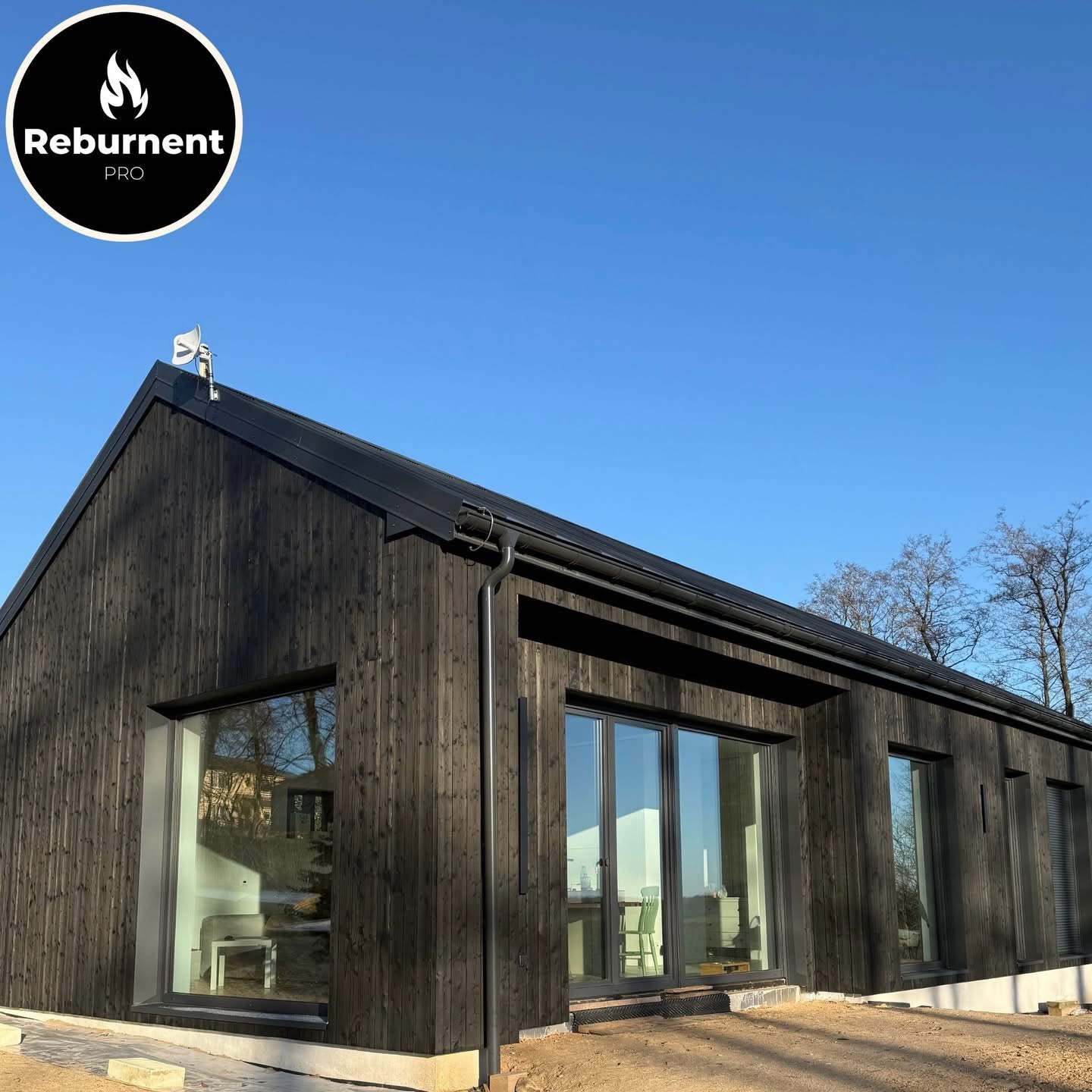 Modern charred timber house with large sliding glass doors