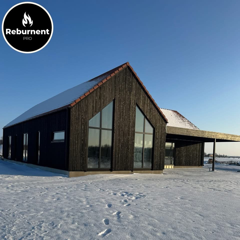 Charred timber house in a winter landscape