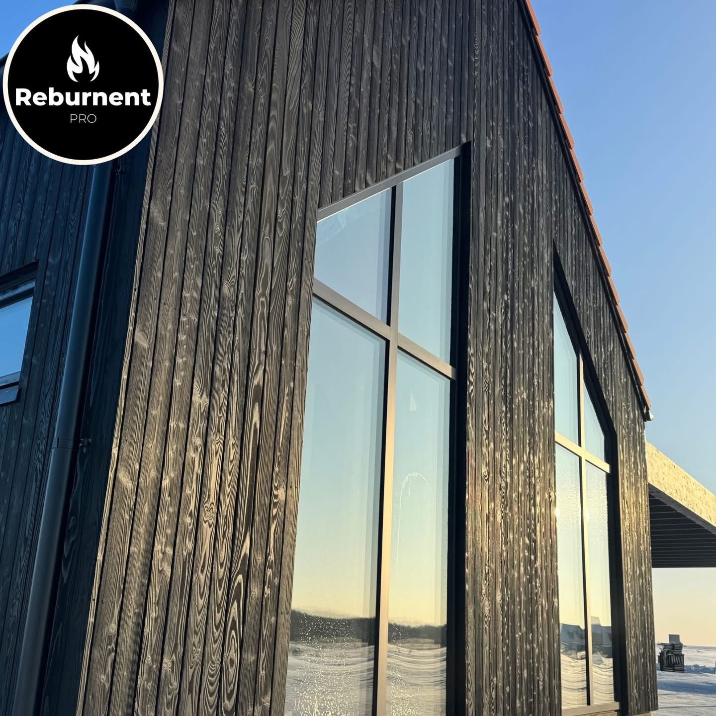 Charred timber gable with floor-to-ceiling glazing